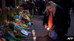 A woman outside the main Synagogue in Copenhagen lights a candle to honor those killed by a gunman on February 14.