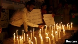 Members of Pakistan's Shi'ite community light candles for the victims and to condemn the attack on a bus in Karachi on May 13.