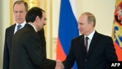 Russian President Vladimir Putin (right) shakes hands with Iran's ambassador to Russia, Mehdi Sanaei, during a ceremony to receive foreign ambassadors' credentials in Aleksandrovsky Hall in the Grand Kremlin Palace in Moscow on January 16.