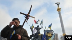 A pro-EU protester crosses himself during a religious service on Independence Square in Kyiv on December 13.