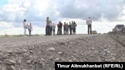 Құрылысы тоқтап тұрған Орталық - Шығыс автожолында тұрған жұмысшылар. Павлодар облысы, 26 шілде 2016 жыл.