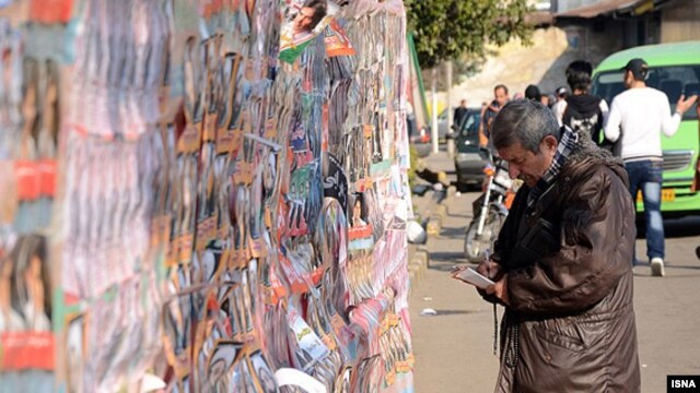 An Iranian man looks at election posters during a week of campaigning ahead of a parliamentary poll on March 2