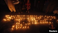Members of the Pakistani Christian community light oil lamps during a protest rally to condemn a deadly suicide attack on a Christian church in Peshawar on September 22, which killed more that 80 people.
