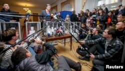 Ukrainian President Petro Poroshenko (center) talks to the media as he visits a polling station during parliamentary elections in Kyiv on October 26.