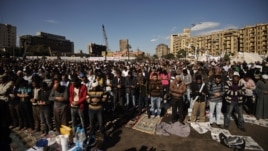 Protesters perform the Friday midday prayer on Cairo’s landmark Tahrir Square.