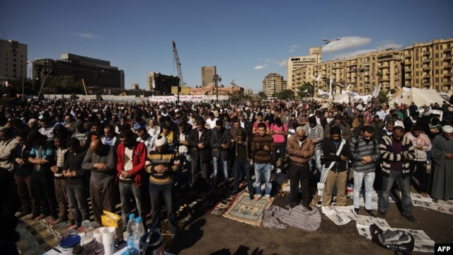 Protesters perform the Friday midday prayer on Cairo’s landmark Tahrir Square.