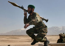An Afghan soldier leaps from a van to take up position outside the Pol-e Charkhi prison, 26 February