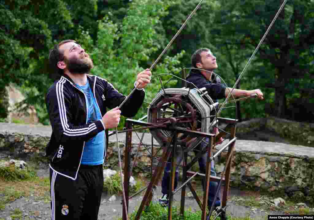 Sergo Mikhelidze and a friend deliver lunch to Maxime by using a winch. Everything atop the pillar was either carried or winched up by volunteers.