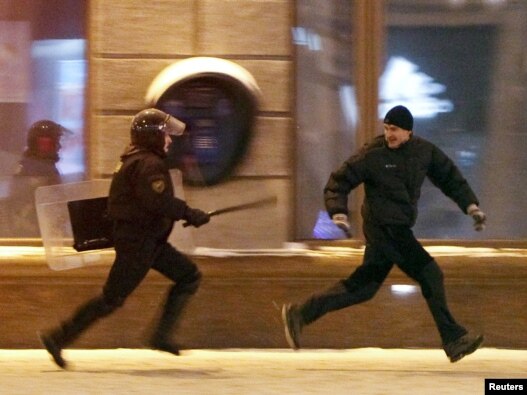 A riot policeman chases a protester during an opposition rally denouncing the results of presidential elections in central Minsk on December 19.