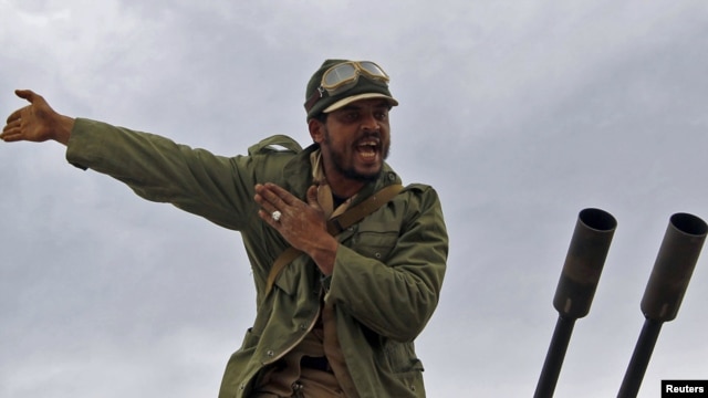 A rebel fighter reacts to incoming shells fired by soldiers loyal to Moammar Qaddafi. The rebels started out strong, but appear to be losing territory day-by-day.