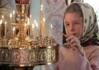 A girl lights a candle, as Russia marks its new holiday (AFP)