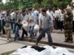 Andijon residents carry the body of a victim of the clashes