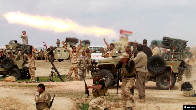 Shi'ite fighters launch a rocket toward Islamic State militants during heavy fighting in Salah al-Din Province on March 4.