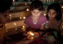 Children lighting candles on October 7 in memory of those killed in Margalla Towers (epa)