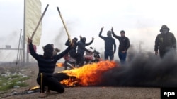 Iraqi Sunni fighters burn tires to close the road as Iraqi security forces launch a military operation in the western province of Anbar on December 30.