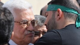 Palestinian President Mahmud Abbas (left) welcomes a prisoner wearing a Hamas headband following the release of hundreds of prisoners from Israeli jails in October.