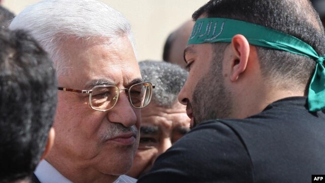 Palestinian President Mahmud Abbas (left) welcomes a prisoner wearing a Hamas headband following the release of hundreds of prisoners from Israeli jails in October.