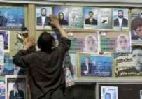 Electoral official hanging sanctioned campaign posters ahead of this month's vote