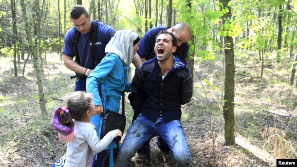 Mađarski policajac hapsi izbeglice iz Sirije koje su ušle u Mađarsku, ilustrativna fotografija