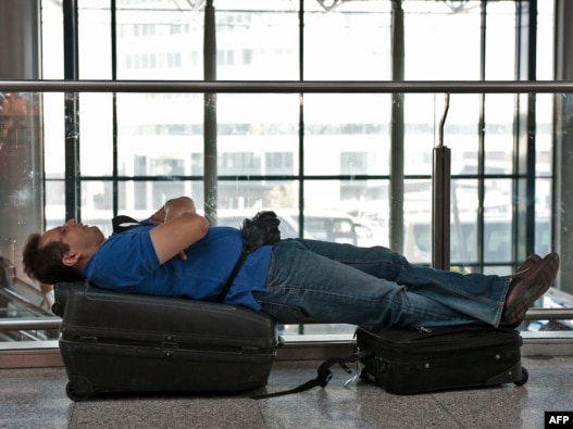 Italy - A passenger rests on his suitcases at Fiumicino airport near Rome, 19Apr2010 