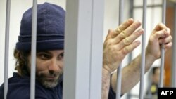 British Greenpeace International activist Iain Rogers holds the bars of a cell during his bail hearing in Russia on October 22.