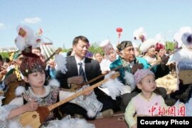 Казахи района Толы в Китае устанавливают  рекорд массовой игры на домбре 30 мая 2010 года. Фото из сайта<br />
www.chinanews.com