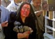 An Iraqi mother, her face covered by the blood of her two police-officer sons, holds their shoes during their funeral procession in Ba'qubah (AFP)