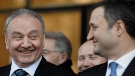 Newly elected President Nicolae Timofti (left) smiles at Prime Minister Vlad Filat during a parliament session in Chisinau on March 16.