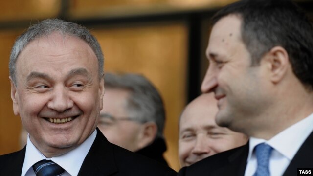 Newly elected President Nicolae Timofti (left) smiles at Prime Minister Vlad Filat during a parliament session in Chisinau on March 16.