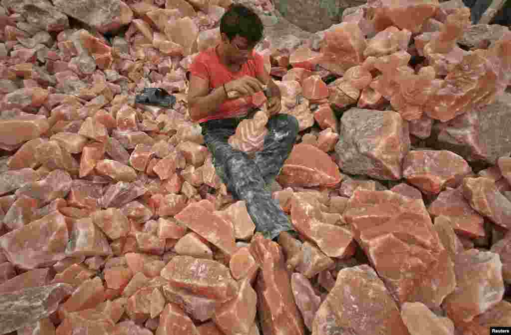 A man in Lahore applies the final touches to a sculpture made from rock salt. 