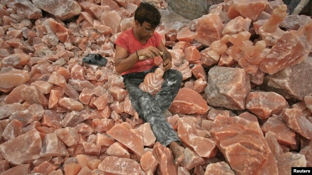 A man applies the final touches to a sculpture made from Himalayan pink rock salt on the outskirts of Lahore.