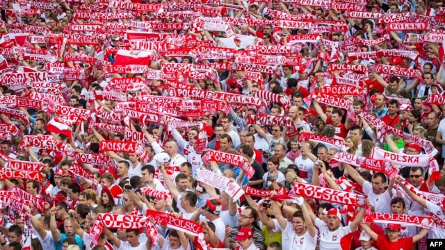 Polish football fans cheer their team in the Warsaw fanzone during Poland's game with Greece on June 8.