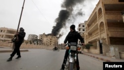 A boy looks back at a building damaged by what activists say was shelling by government forces during fighting in Raqqa province on March 13.