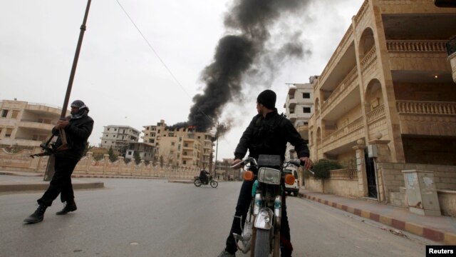 A boy looks back at a building damaged by what activists say was shelling by government forces during fighting in Raqqa province on March 13. 