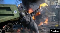 Antigovernment protesters hurl Molotov cocktails as they attack an office of the pro-presidential Party of the Regions in Kyiv on February 18.