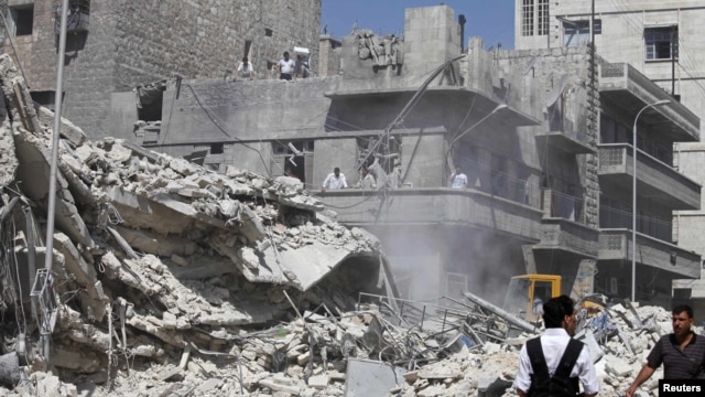 Civilians and members of the Free Syrian Army inspect a damaged building in the al-Kalaseh neighborhood of  Aleppo, after a government jet air strike on September 19.