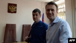 Kremlin critic and opposition leader Aleksei Navalny (right) and his brother Oleg stand in a courtroom in Moscow on April 24.
