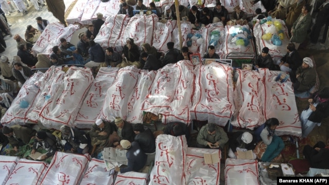 Pakistani Shi'ite Muslims gather around the coffins of the bombing victims as they demonstrate in Quetta on February 18.