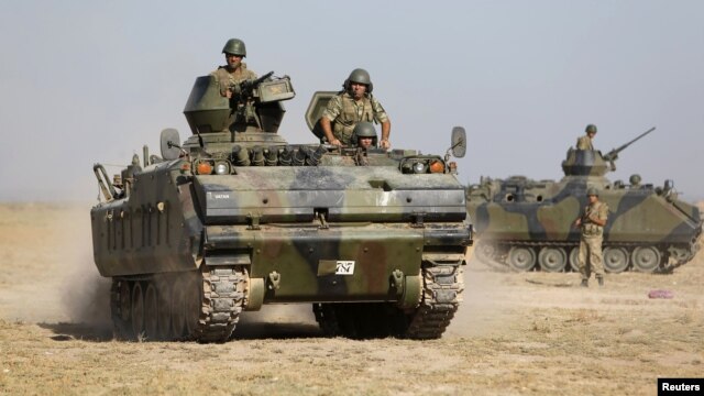 Turkish military armored personnel carriers take positions on the Turkish-Syrian border near the Akcakale border crossing on October 4.