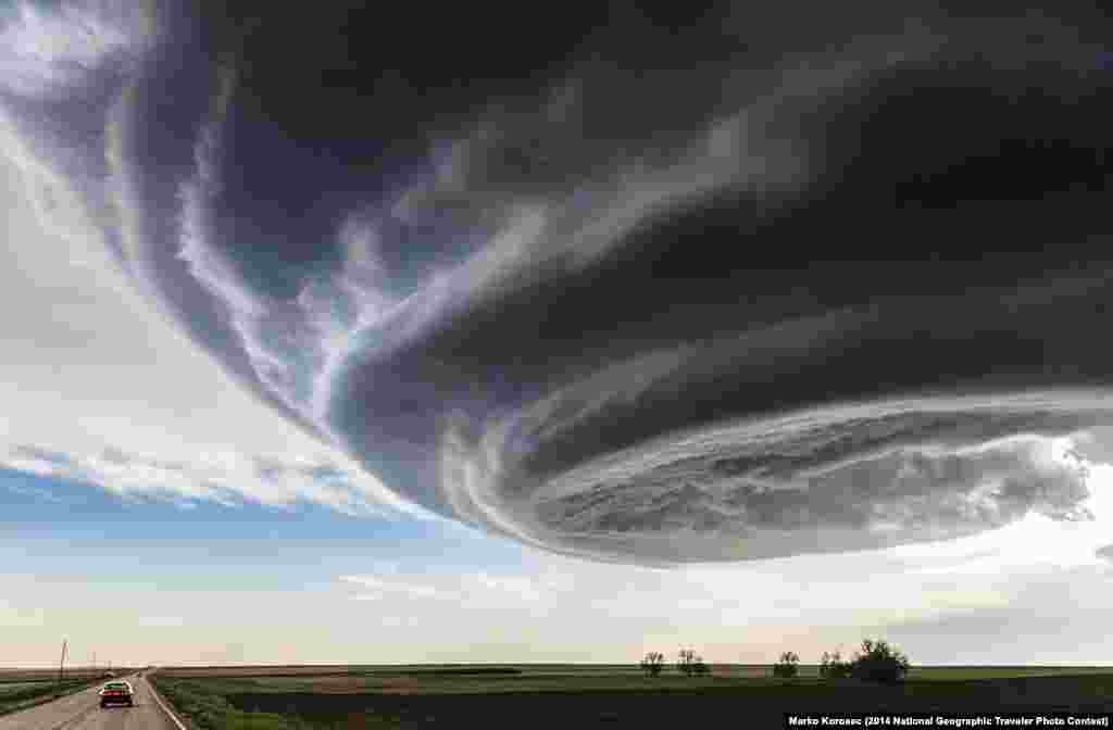 Grand Prize: "The Independence Day" by Marko Korošec. Julesburg, Colorado, United States. "While on storm chasing expeditions in the Tornado Alley in USA I have encountered many photogenic supercell storms. This photograph was taken while we were approaching the storm near Julesburg, Colorado on My 28th, 2013. The storm was tornado warned for more than one hour, but stayed an LP storm through all its cycles and never produced a tornado, just occasional brief funnels, large hail and some rain." 