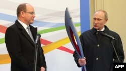 Russian President Vladimir Putin (right) hands over an Olympic torch to Prince Albert II of Monaco as a present for his private collection of Olympic torches.