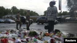 A woman looks at floral tributes placed near the scene of the killing of British soldier Lee Rigby in Woolwich, London, on May 23.