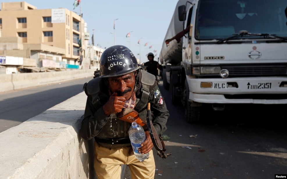 A policeman washes away the effects of tear gas fired by police after Shi'ite Muslim men blocked the main national highway and railway tracks to protest raids of both Sunni and Shi'ite religious seminaries and the detention of an unspecified number of people, in Karachi, Pakistan. (Reuters/Akhtar Soomro)