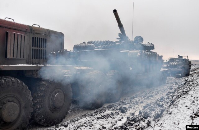 A Ukrainian military truck tows a tank damaged during fighting with pro-Russian separatist forces outside Debaltseve on February 10.