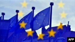 EU flags are reflected at the entrance of the Berlaymont building of the EU Commission in Brussels