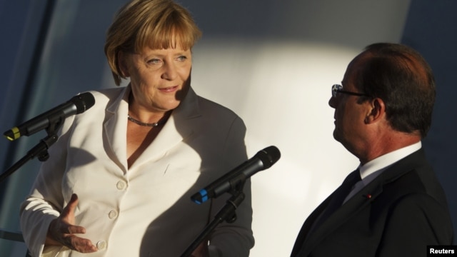 German Chancellor Angela Merkel (left) and France's President Francois Hollande address the media before talks at the Chancellery in Berlin on August 23. 