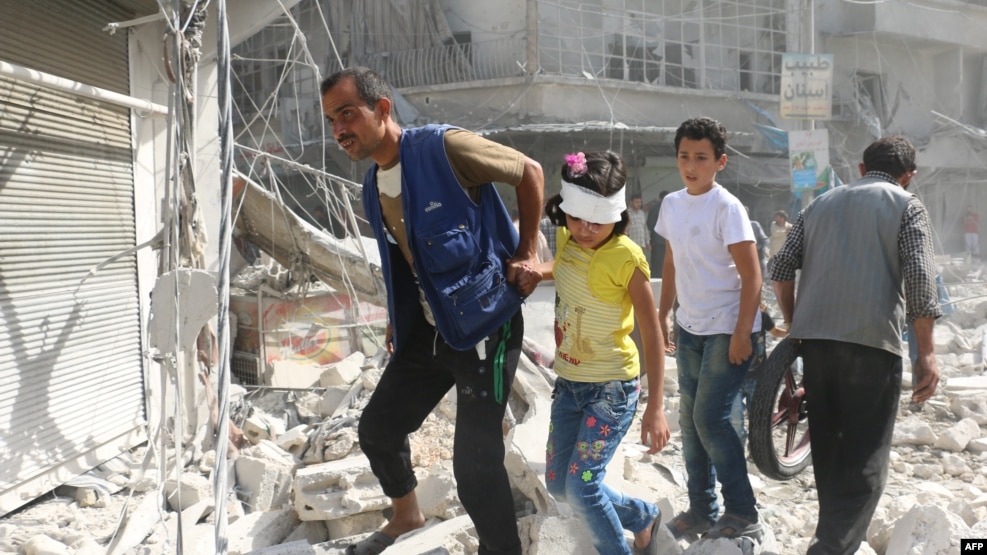 Syrians walk over rubble following air strikes on the rebel-held Fardus neighborhood of the embattled Syrian city of Aleppo on October 12.