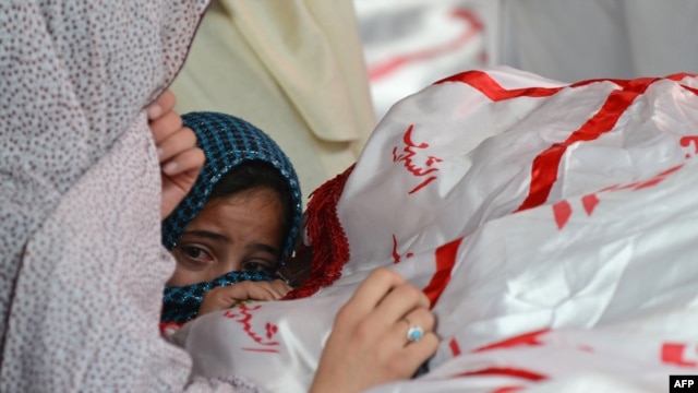 A child reacts as Shi'ite Hazaras gather around the coffin of a bomb victim on the third day of protests following the bombing in Quetta on February 19.