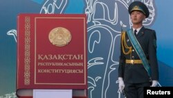 Қазақстан конституциясын бейнелейтін макет кітаптың жанында тұрған сарбаз. Алматы, 30 тамыз 2014 жыл. (Көрнекі сурет)