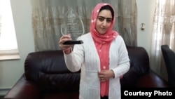 Afghanistan--Radio Azadi journalist Nazeefa Mahboobi displays award she received from local NGOs for her investigative reporting. April 2016.